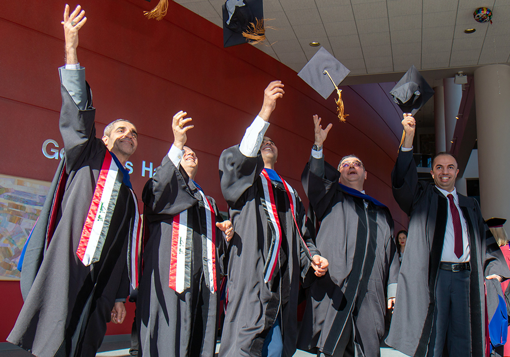 group of graduates throwing up their mortar board hats in celebration.