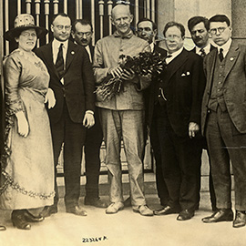 Eugene Debs, at center with flowers, who was serving a prison sentence for violating the Espionage Act, on the day he was notified of his nomination for the presidency on the socialist ticket by a delegation of leading socialist